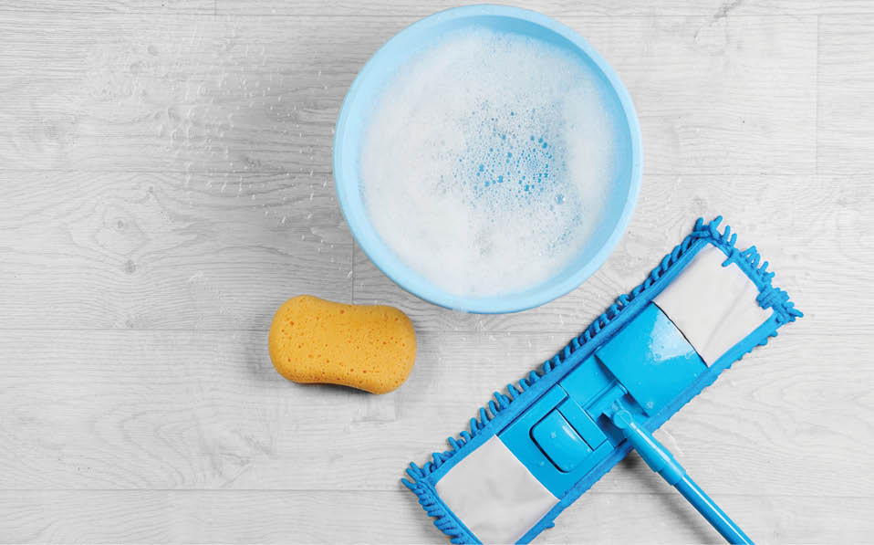 Mopping, blue wet microfiber mop with detergent  Cleaning disinfection kit on a white floor isolated  Housekeeping concept